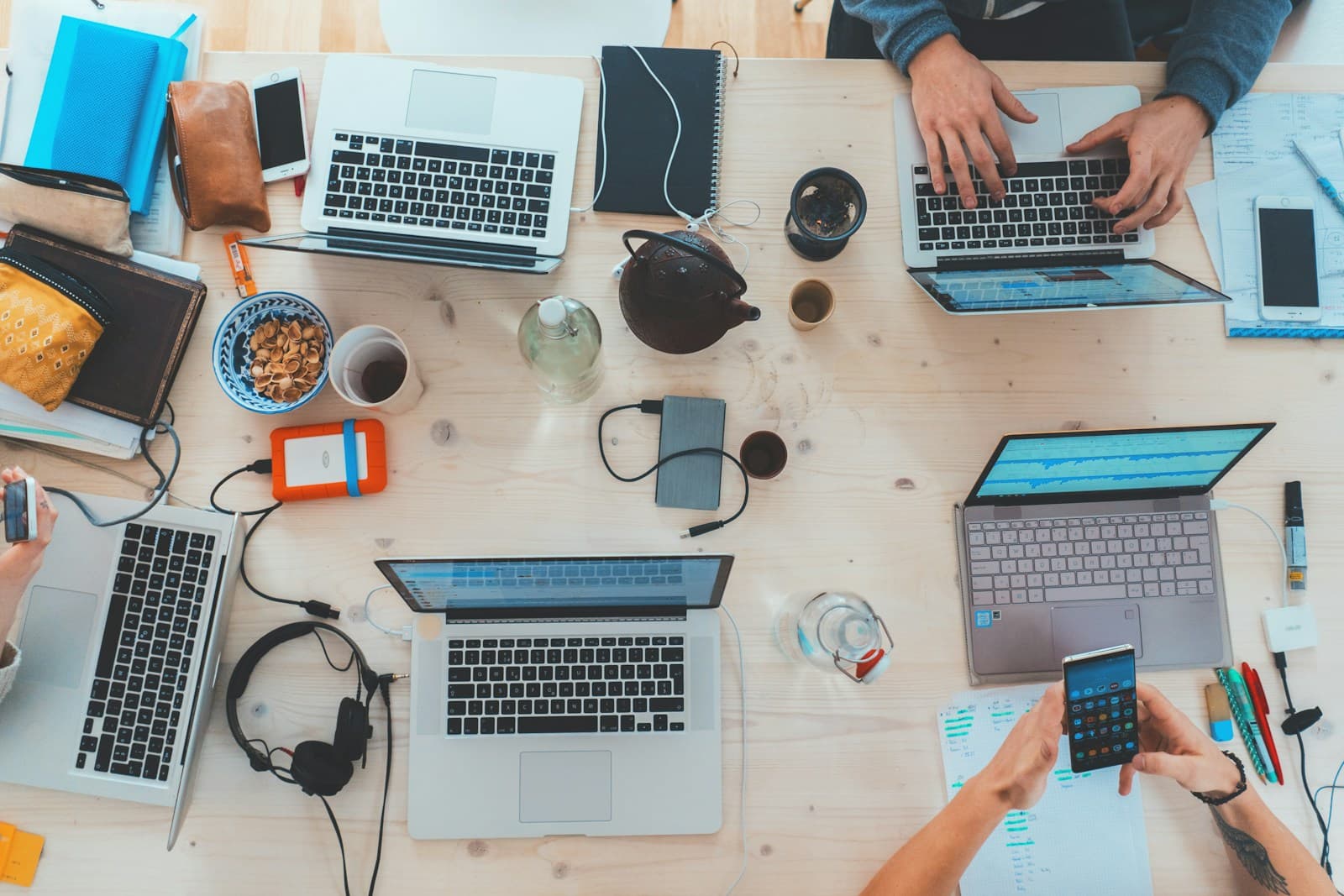 Overhead view of a team working with laptops at a wooden table